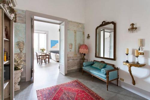 uma sala de estar com um sofá azul e um espelho em Piazza Marina Chic em Palermo