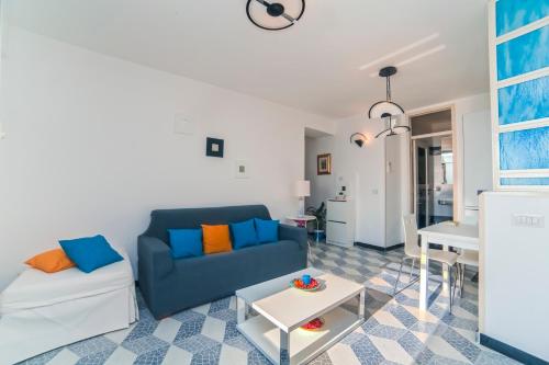sala de estar con sofá azul y mesa en La Casetta, en Amalfi
