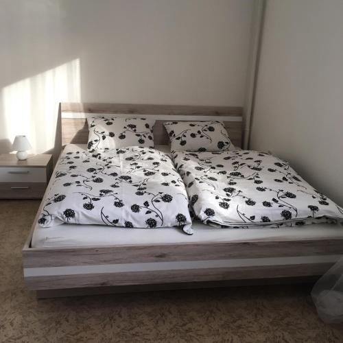 a bed with black and white sheets and pillows at Apartmán Na Horách in Zlatá Olešnice