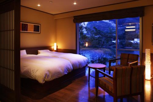 a bedroom with two beds and a large window at Satorikan in Gosen