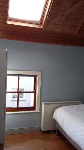 a bedroom with a bed and a window at Rings Coach House Retreat in Carlow
