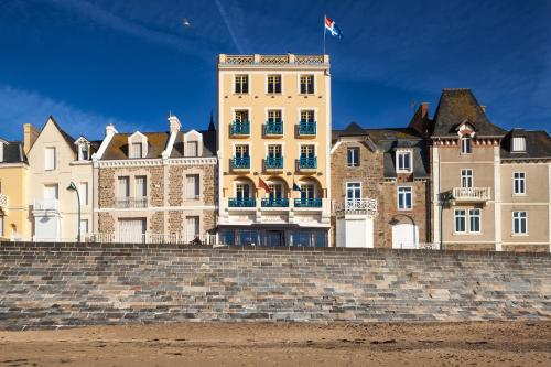 un gran edificio en la parte superior de una pared de ladrillo en Ambassadeurs Logis Hotel, en Saint-Malo