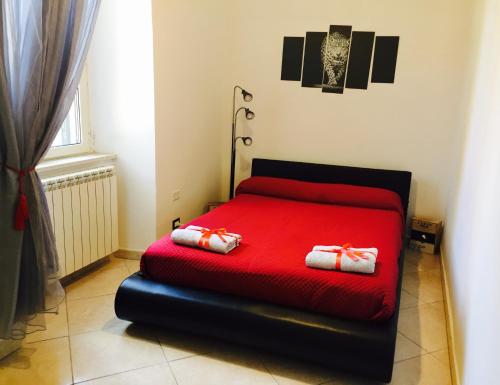 a bedroom with a red bed with two pillows on it at Aloha House in Formia