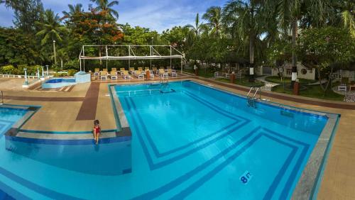 馬哈巴利普拉姆的住宿－愛迪爾海灘度假酒店，一个大型游泳池,前面有一个女人