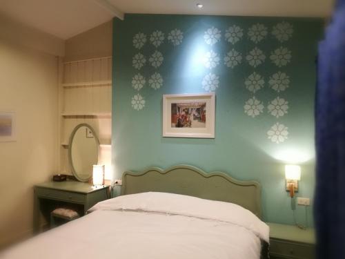 a bedroom with a bed and a green wall at Bann Vimansamutr in Cha Am