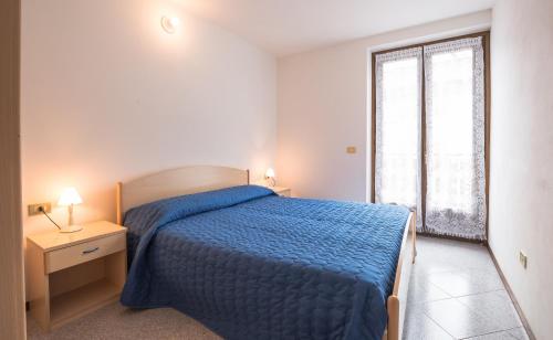 a bedroom with a blue bed and a window at Casa Lori Green Holiday in Ledro