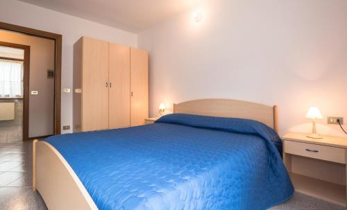 a bedroom with a bed with a blue blanket at Casa Lori Green Holiday in Ledro