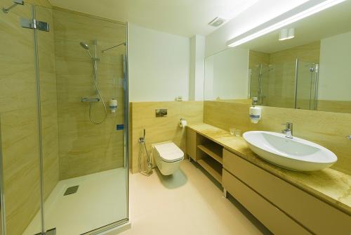 a bathroom with a sink and a toilet and a shower at Hotel Garden in Siedlce