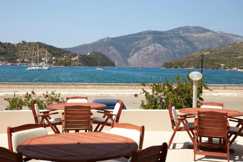a group of tables and chairs next to the beach at Mentor Hotel in Vathi, Ithaka