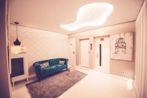 Una sala de estar con un sofá verde y un televisor. en Hostal Lisboa, en Madrid