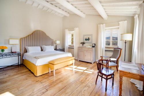 a bedroom with a bed and a table and chairs at Borgo Del Cabreo in Greve in Chianti
