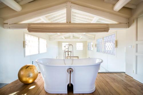 uma banheira branca num quarto com tecto em Borgo Del Cabreo em Greve in Chianti