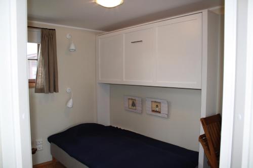 a small bedroom with a bed and a cabinet at Slite Strand resort in Slite