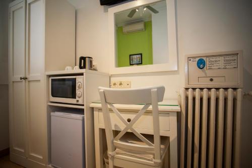 a kitchen with a microwave and a chair in it at AVA Rooms in Madrid