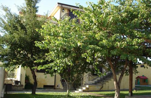 two trees in front of a building with stairs at Agriturismo Casale Di Gricciano in Cerveteri