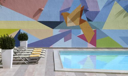 a mural on the side of a building with a pool at Amarilia Hotel in Athens