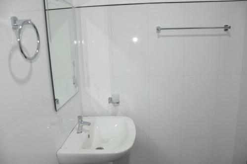 a white bathroom with a sink and a mirror at Bon Voyaage Tourist Inn in Trincomalee