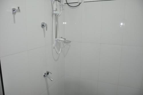 a shower in a white bathroom with a shower at Bon Voyaage Tourist Inn in Trincomalee