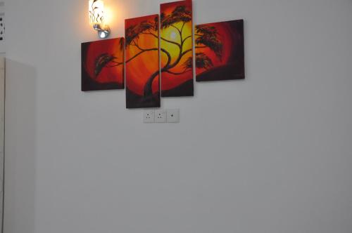 a group of paintings hanging on a wall at Bon Voyaage Tourist Inn in Trincomalee