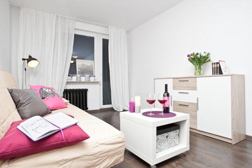 a living room with a couch and a table with wine glasses at Apartament Pomorska in Jelitkowo