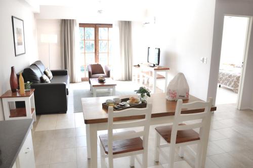 a kitchen and living room with a table and chairs at Green Sea Apart Hotel in Pinamar