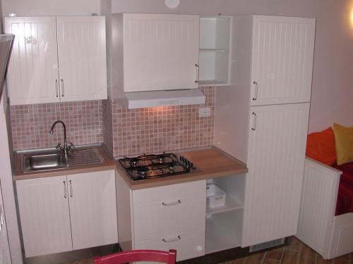 リオ・マリーナにあるRaffaella Apartmentの小さなキッチン(白いキャビネット、シンク付)