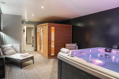 een badkamer met een paars bad in een kamer bij Hôtel-Spa-Piscine Le Petit Castel Beuzeville-Honfleur in Beuzeville