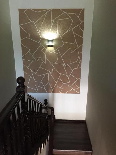 a stairway with a wall with a light on it at Homestay Muar in Muar