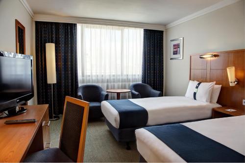 ロンドンにあるホリデイ イン ロンドン ブルームズベリーのベッド2台、薄型テレビが備わるホテルルームです。