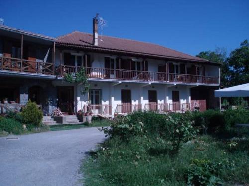 a large white house with a porch and balcony at Guesthouse Sinoi in Vitina