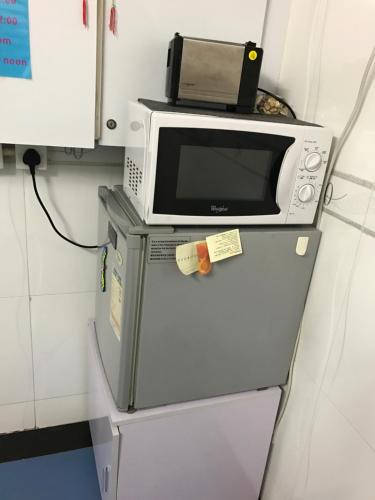 a microwave sitting on top of a refrigerator at Beverly Guest House in Hong Kong