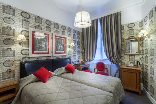 a bedroom with a large bed with red pillows at Grand Hôtel de L'Univers Saint-Germain in Paris