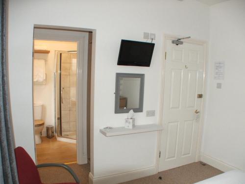 a room with a mirror and a television on a wall at Westbury Lodge in Shanklin