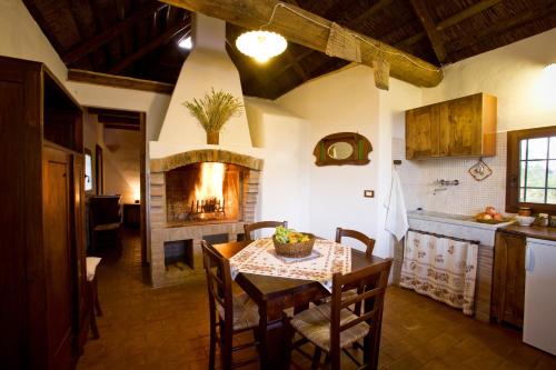 Il comprend une cuisine et une salle à manger avec une table et une cheminée. dans l'établissement Agriturismo Bassara Le Capanne, à Argenta