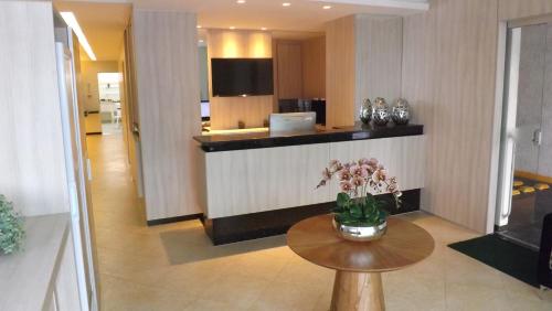 a lobby with a table with flowers on it at Hotel Marajó in Uberlândia