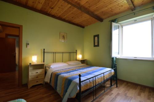 1 dormitorio con 1 cama en una habitación con ventana en Agriturismo Al Rifugio DiVino, en Belvedere Ostrense
