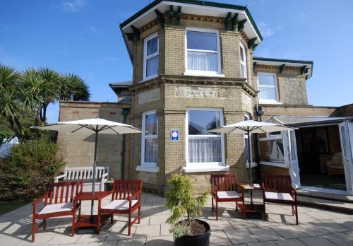 a group of chairs and umbrellas in front of a building at Westbury Lodge in Shanklin