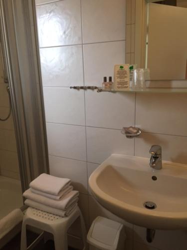 a white bathroom with a sink and a toilet at Pension Wagner in Ingolstadt