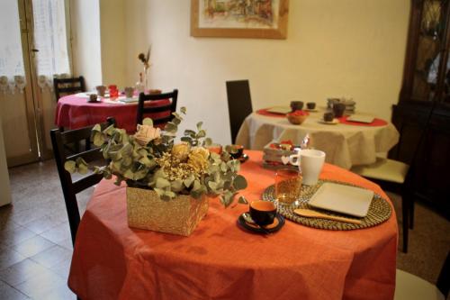 una mesa con mantel naranja y una mesa con ordenador portátil en Antica Corte del Castello, en Fiano Romano