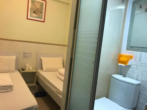 Habitación pequeña con aseo y espejo. en Beverly Guest House en Hong Kong