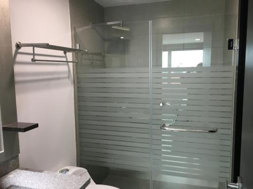 y baño con ducha de cristal y aseo. en LUJO CONFORT SEGURIDAD Quo 101, en Guayaquil