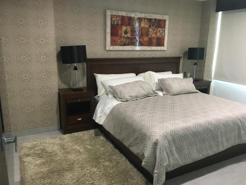 um quarto com uma cama grande e uma mesa de cabeceira com uma cama sidx sidx sidx em LUJO CONFORT SEGURIDAD Quo 101 em Guayaquil