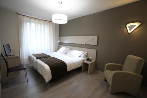 una habitación de hotel con una cama y una silla en Los Guardeses, en Solares