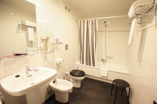 a white bathroom with a sink and a toilet at Los Guardeses in Solares