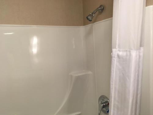 a bathroom with a shower and a white shower curtain at Quality Inn Sept-Iles in Sept-Îles