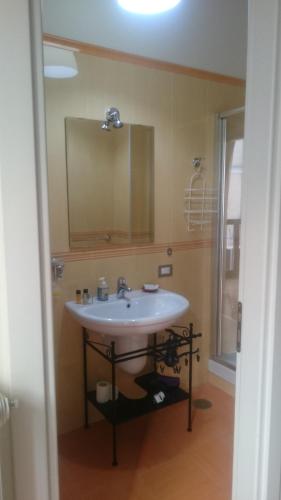 a bathroom with a white sink and a mirror at B&B Verdi in Salerno