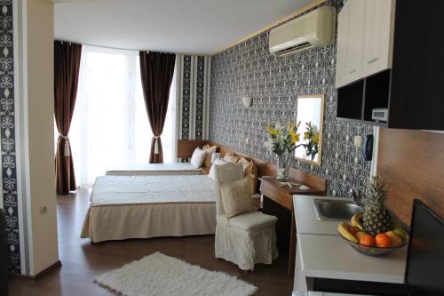 ein Schlafzimmer mit einem Bett und einem Waschbecken in einem Zimmer in der Unterkunft Семеен Хотел Идън in Sweti Wlas