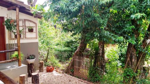 a fence in front of a tree next to a house at Hotel Santiago in Lindóia