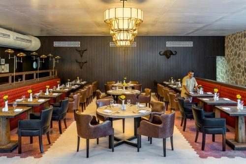 a restaurant with tables and chairs and a man standing in the middle at El Beso Adults Only at Ocean Riviera Paradise All Inclusive in Playa del Carmen