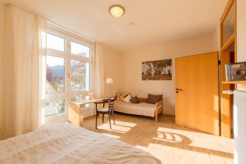 1 dormitorio con cama, escritorio y sofá en Stiftsgut Keysermühle, en Klingenmünster